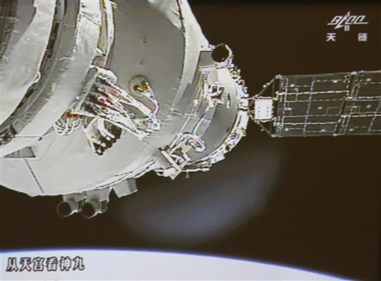 In this image made off the screen at the Beijing Aerospace Control Center in Beijing and released by China's Xinhua News Agency, Shenzhou-9 spacecraft and Tiangong-1 lab module, partly seen on left, are conjoined again Sunday. (AP Photo/Beijing Aerospace Control Center via Xinhua) 